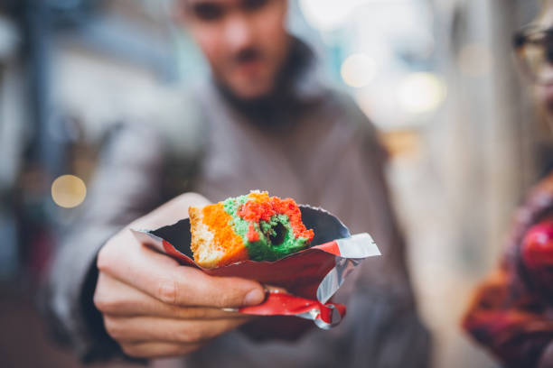 man showing multicoloured biscuit with marijuana